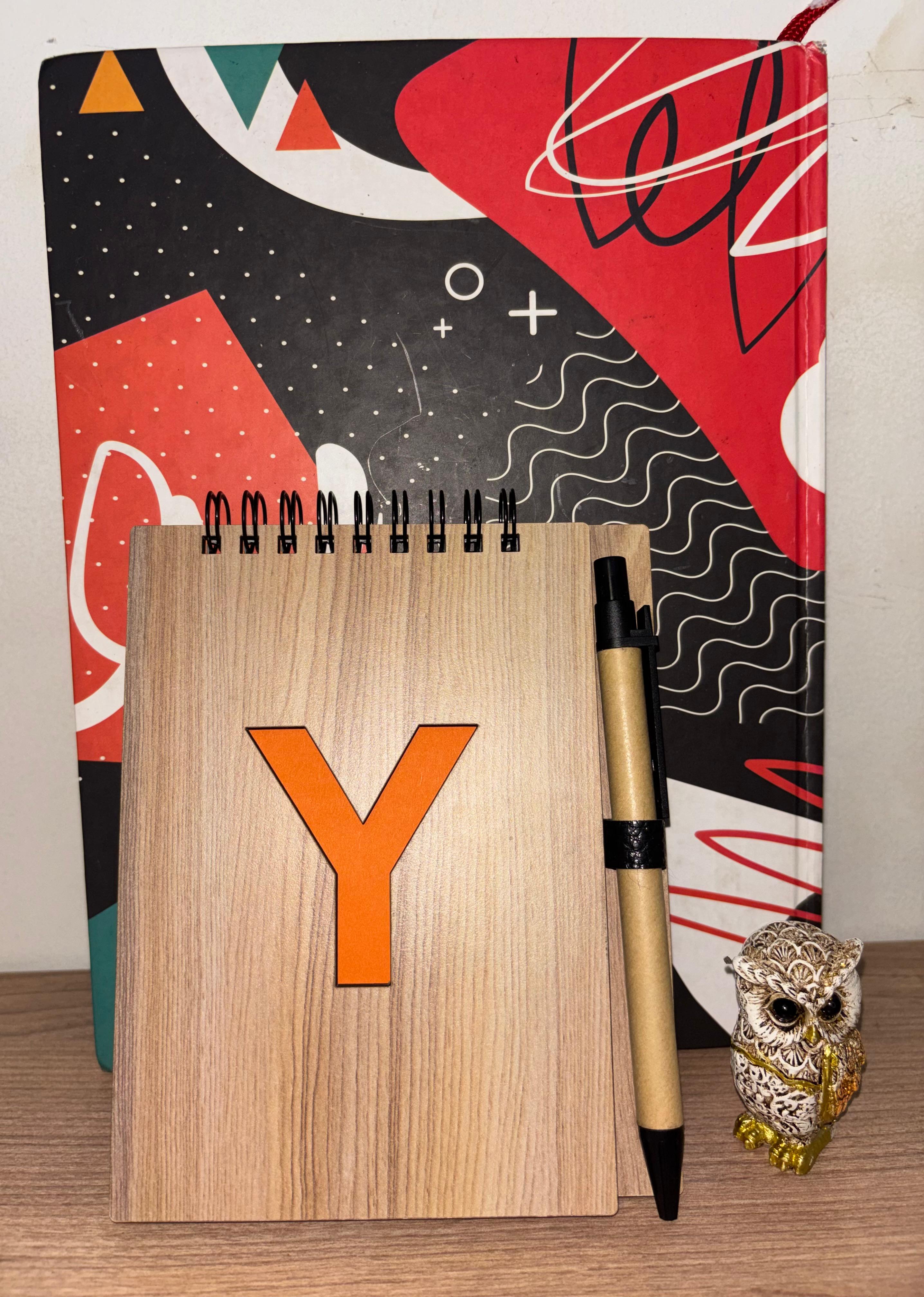 YC notepad with the orange Y logo, a pen, and the little owl souvenir